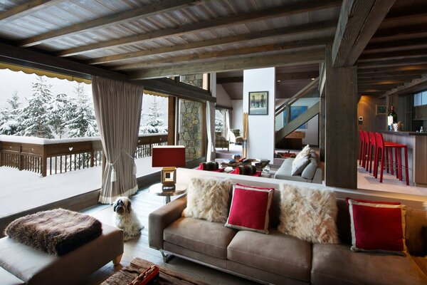 Cozy interior of the first floor of a country house with a snow-covered terrace