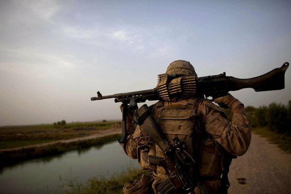 Noche. Soldado en la carretera con un rifle