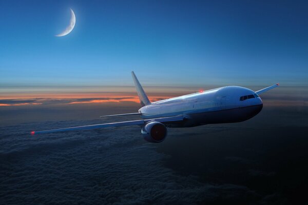 Un avión vuela sobre las nubes en el cielo al atardecer