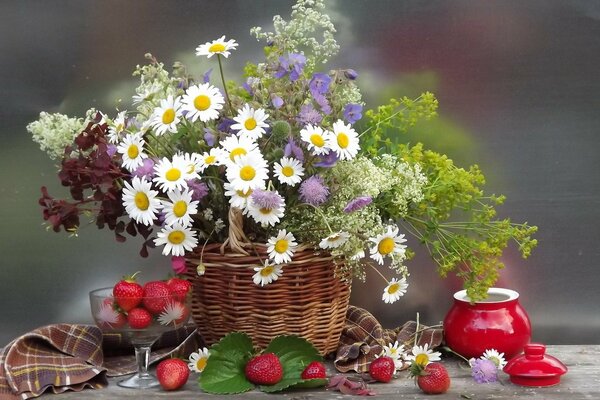 Komposition aus einem Gemälde von bewässerten Blumen und Beeren auf dem Tisch