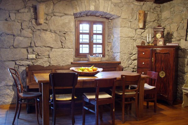 Kamienne ściany i drewniane meble w śródziemnomorskim wnętrzu