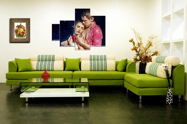 Зеленый диван со столиком, картинами на стене и вазами