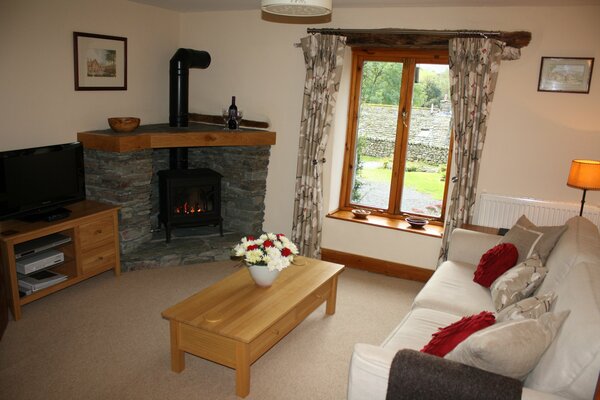 A modest living room in a country house with a sofa and a fireplace