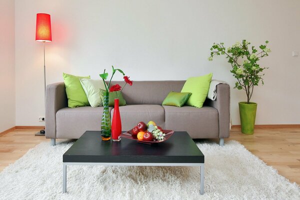 Stylish grey sofa with green cushions