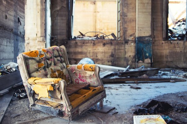 A room in an abandoned house. a collapsed chair