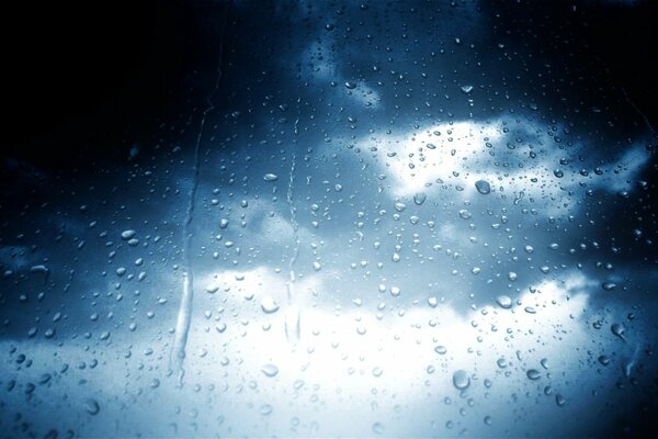 Gouttes de pluie sur verre sur fond de ciel nuageux