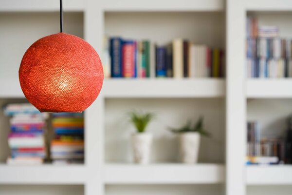 Rote Lampe auf weißem Regalhintergrund