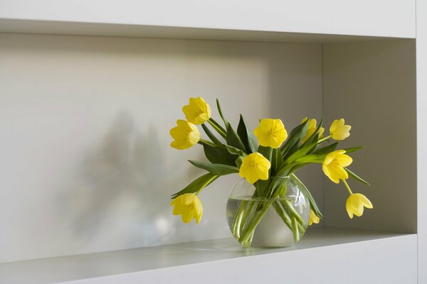 Tulipani gialli in un vaso su uno scaffale