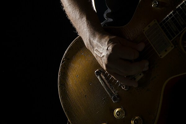 Männliche Hand spielt Gitarre