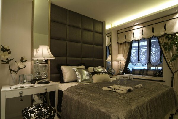 Спальня в роскошном стиле с цветами и лампой на столике