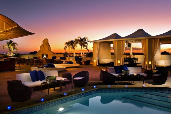 Cafe by the pool with palm trees around