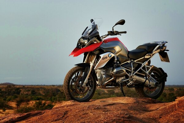 Red and black bmw motorcycle on the background of savannah