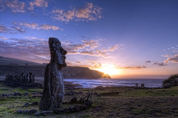 Estatuas en la isla en el fondo de la puesta de sol