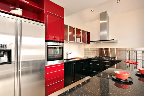 Red lacquered furniture in a large kitchen with extractor hood and refrigerator