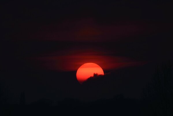 Sunset - moon in blood from behind a cloud