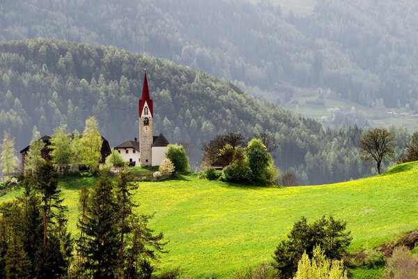 Kapelle auf dem grünen Rasen in den Bergen