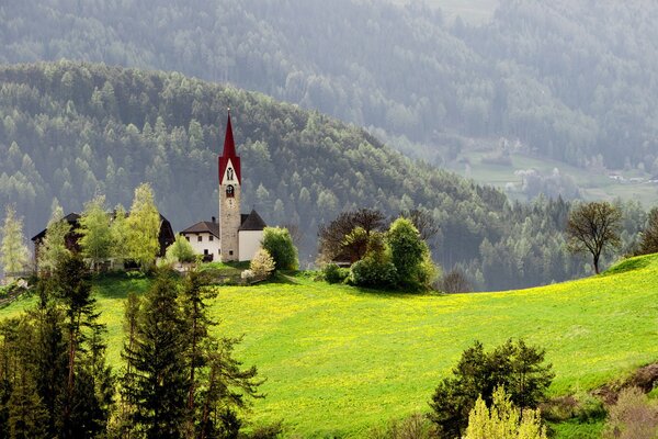 Chapel on the green grass in the mountains