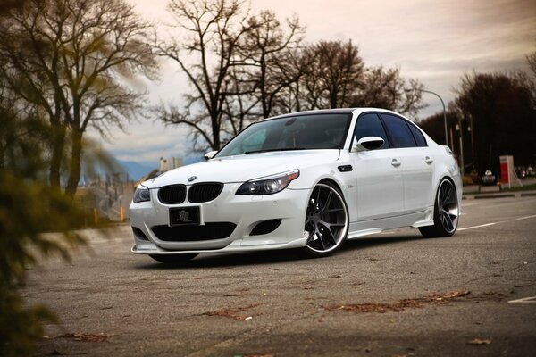 Tinted white BMW on old asphalt