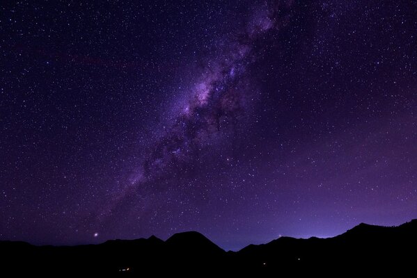 Montañas en el fondo del espacio y la vía láctea