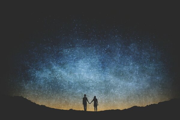 Pareja de enamorados en el fondo del cielo estrellado