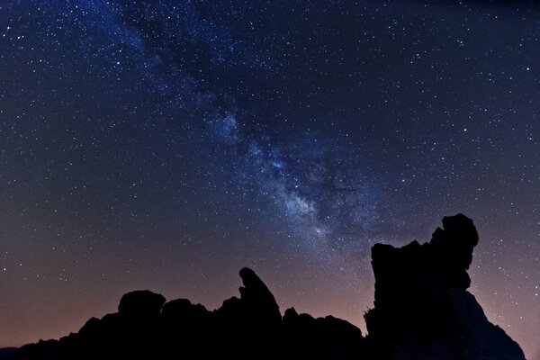 Voie lactée dans le ciel étoilé, montagnes sombres