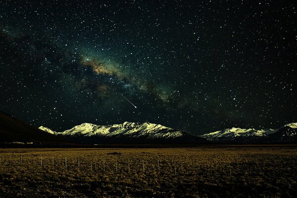 Pure field snowy mountains and the Milky Way