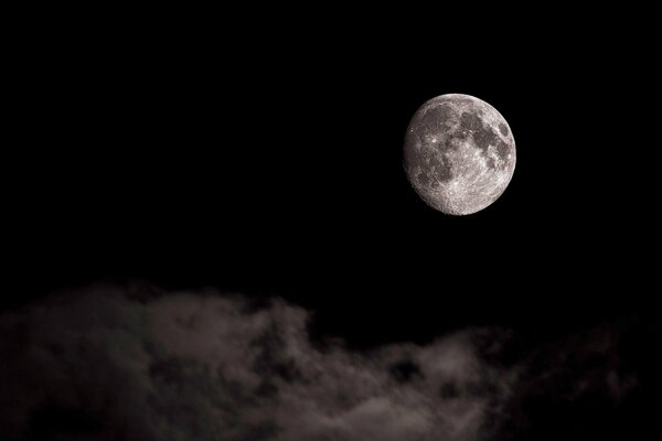 Moon on a black background and floating clouds