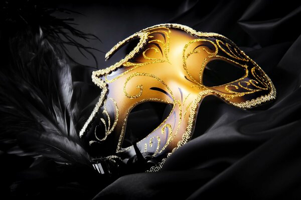 Shiny gold mask on black silk fabric