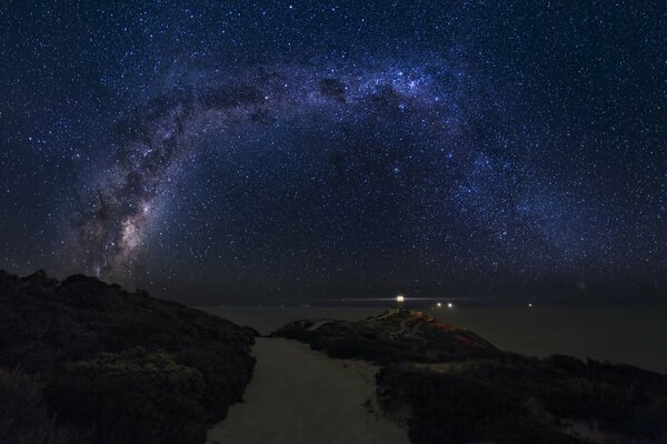 La vía láctea en el fondo de la bahía de la noche