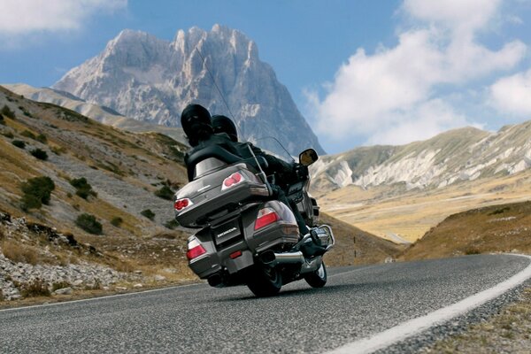 Silbernes Motorrad auf dem Vorplatz in den Bergen