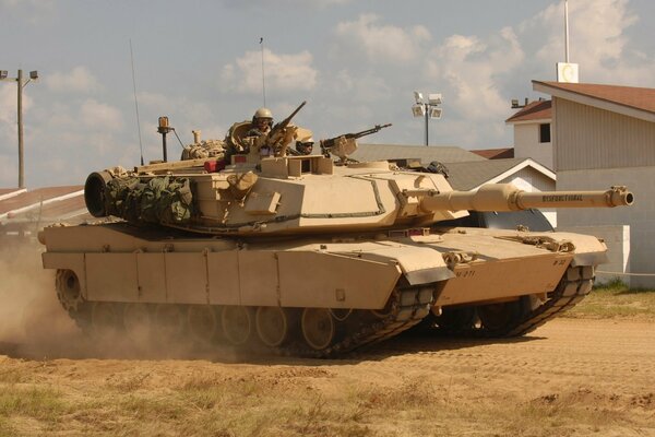 Amerykański czołg pancerny Abrams z czołgistą na wieży w piaszczystej scenerii
