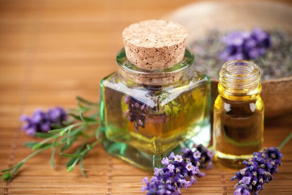 Aceite de lavanda en frascos de vidrio y ramitas de lila