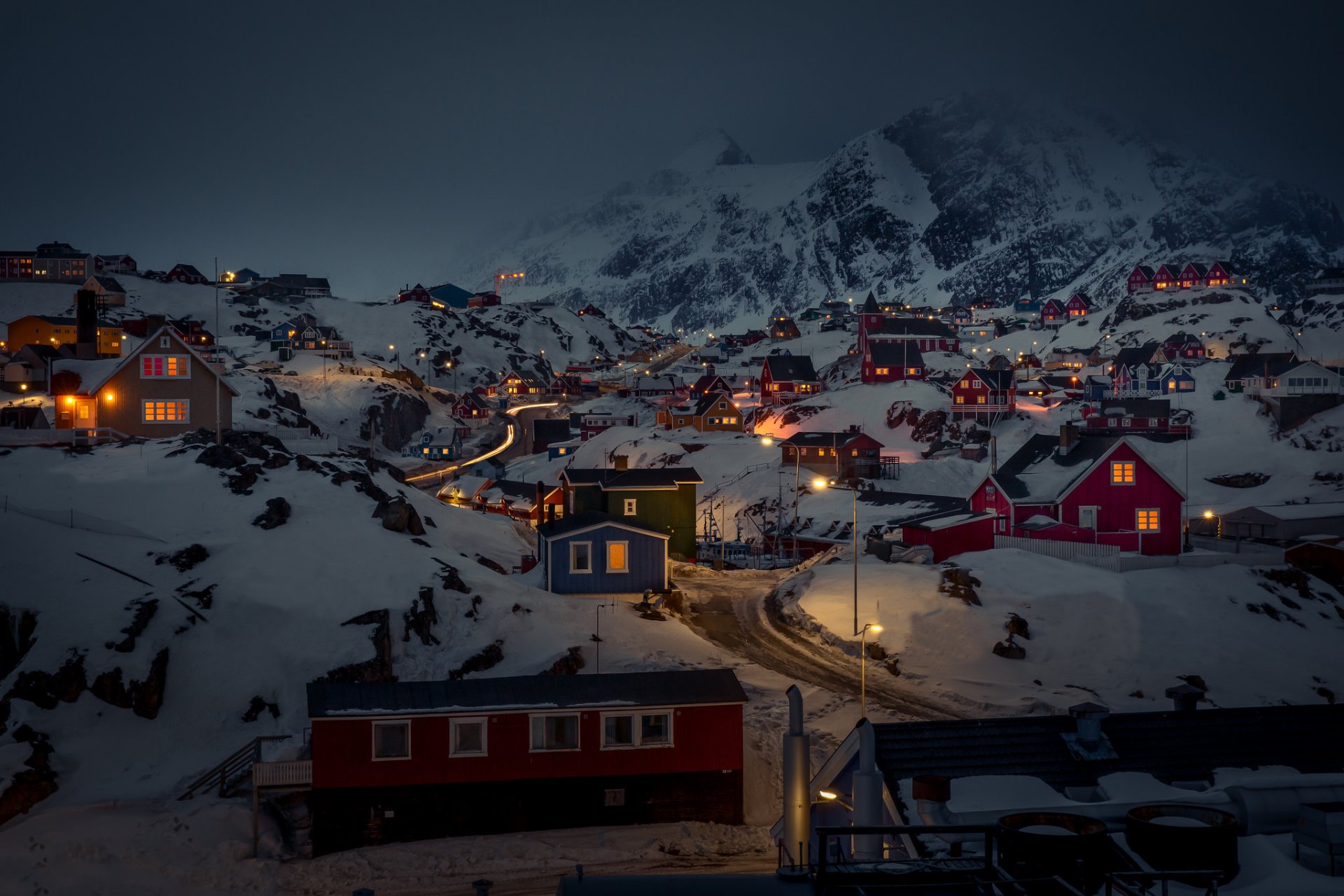 groenlandia sisimiut case luci neve nebbia notte strada montagne nuvole grigie tempesta