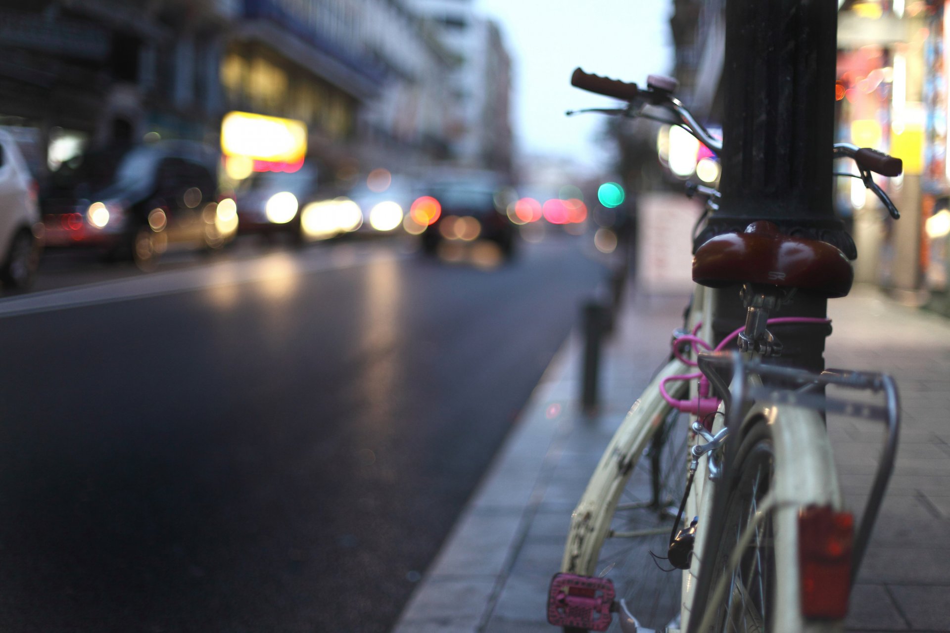 vélo pilier ville trottoir route soirée lumières phares voitures trafic bâtiments rythme