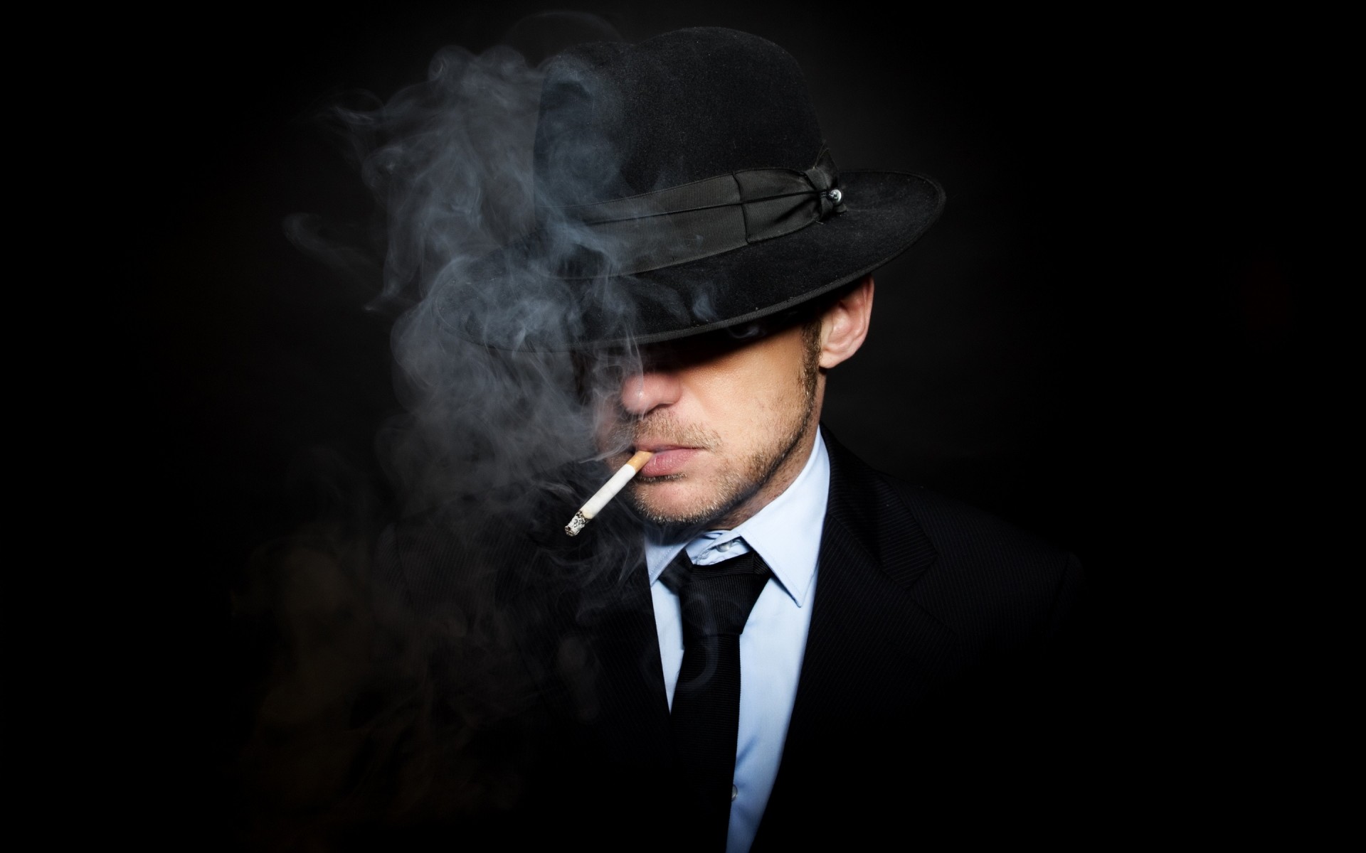 atar traje hombre fondo negro humo sombrero