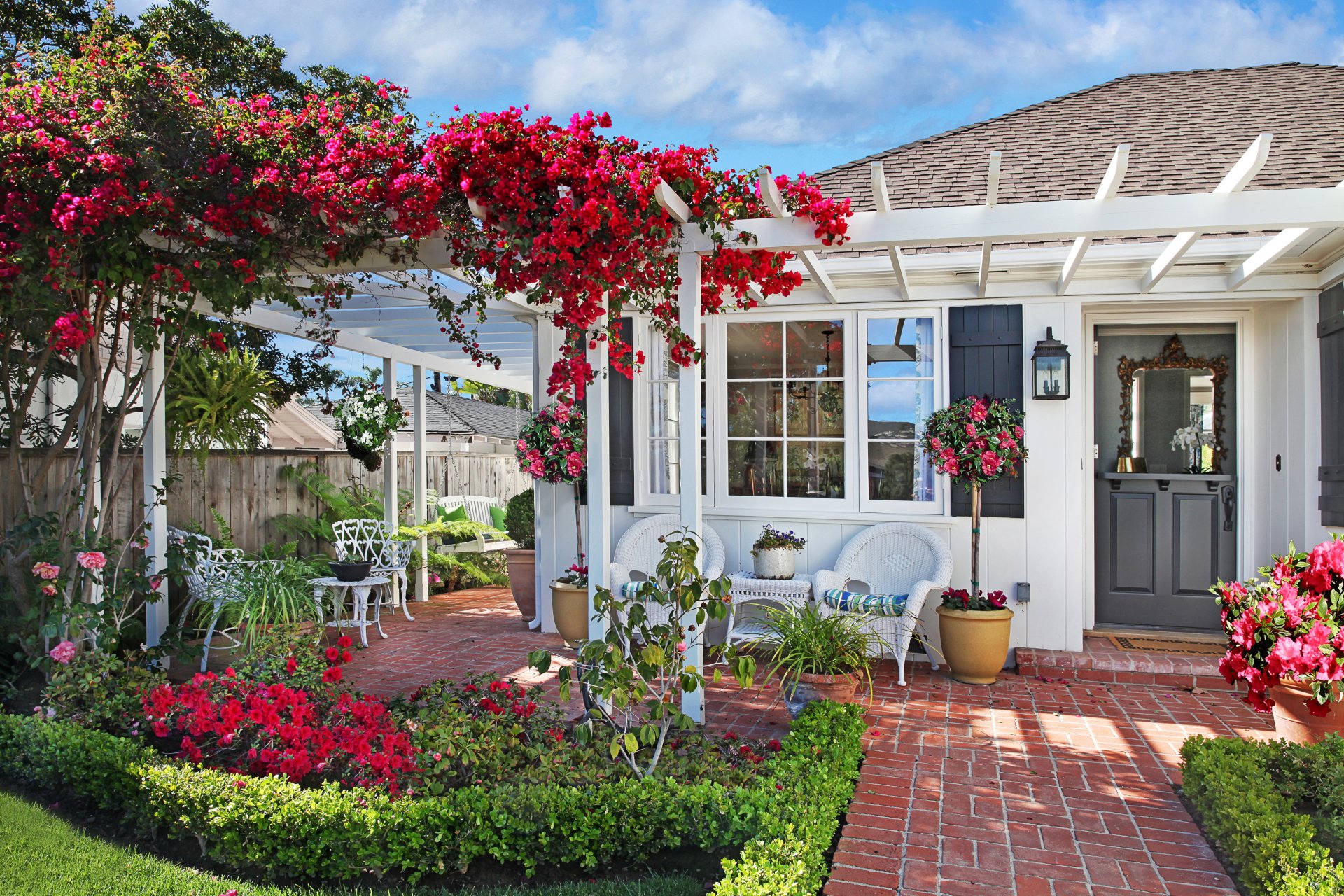 casa jardín flores buganvillas sillas columpio césped hierba