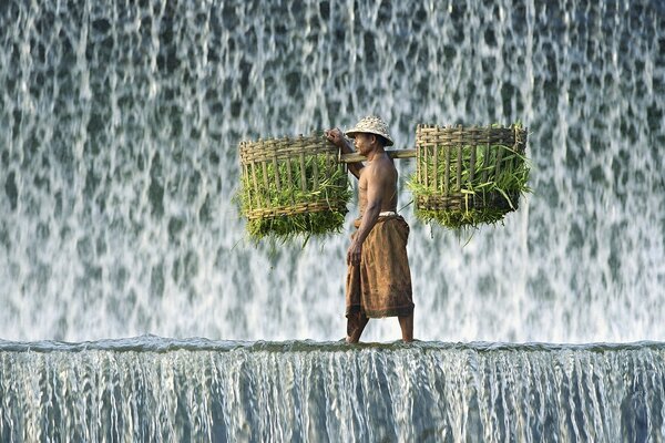 Un homme avec un lourd fardeau à la cascade