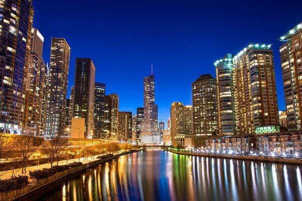 Chicago at night. Skyscrapers are reflected in the waters of the river