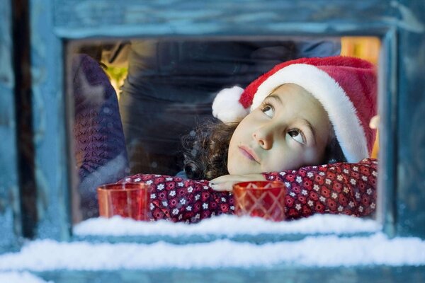 Fille aux yeux bruns à la fenêtre. Dans l attente d un miracle