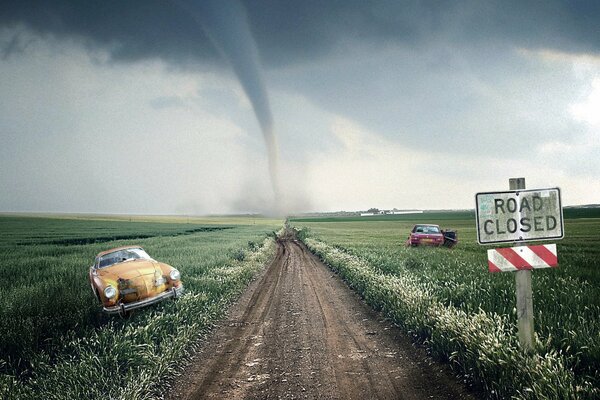 Tornado in avvicinamento, auto abbandonate lungo i bordi di una strada rurale