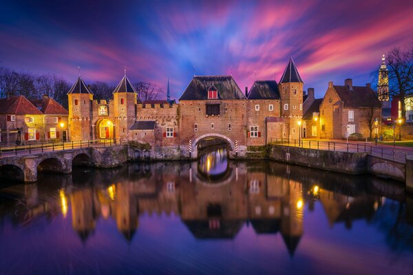 Sur la rive de la rivière éclairée par la lumière violette ancienne forteresse