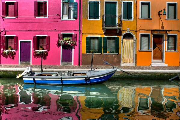 Boat on the water against the background of colored houses of Venice