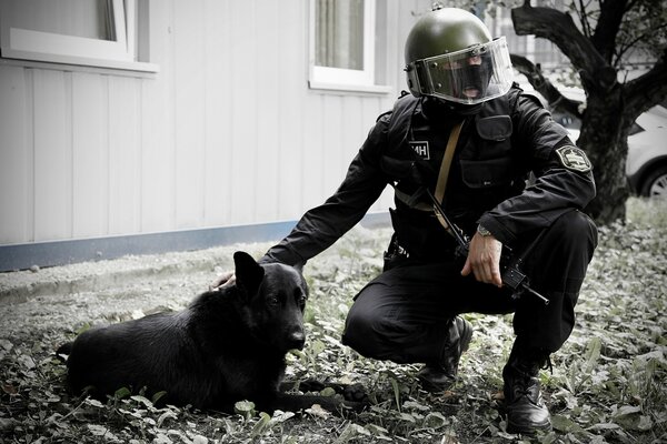 A soldier strokes a lying dog