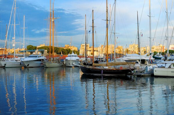Dawn on the pier. Reflection of houses and boats in the morning in the water