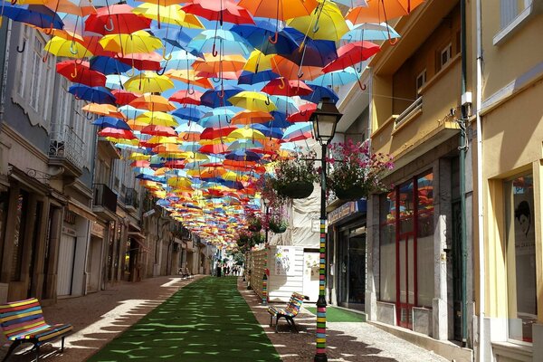 Letnia Portugalia. Otoczona domami ulica i parasole