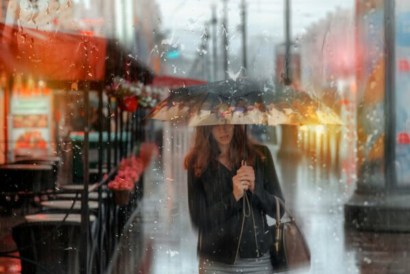 Mädchen unter einem Regenschirm im Sommerregen in St. Petersburg