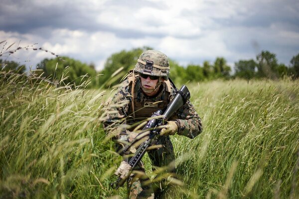 Militaire avec des armes se faufile dans une Prairie pittoresque