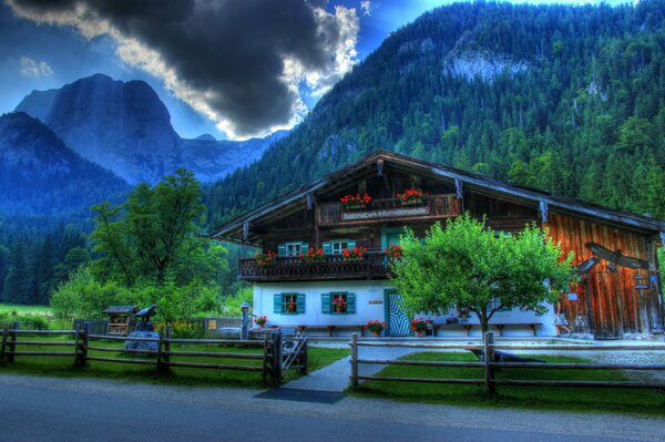 Alemania hdr. La casa detrás de la cual las montañas. Foto del lado de la valla