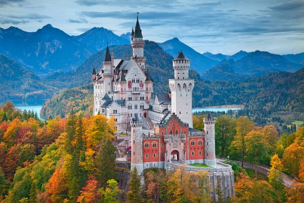 Neuschwanstein Castle on the background of autumn forest and mountains