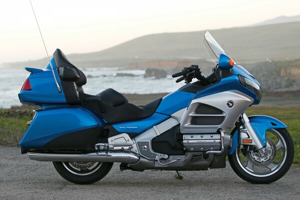 La motocicleta azul se encuentra en el fondo de un lago y montañas